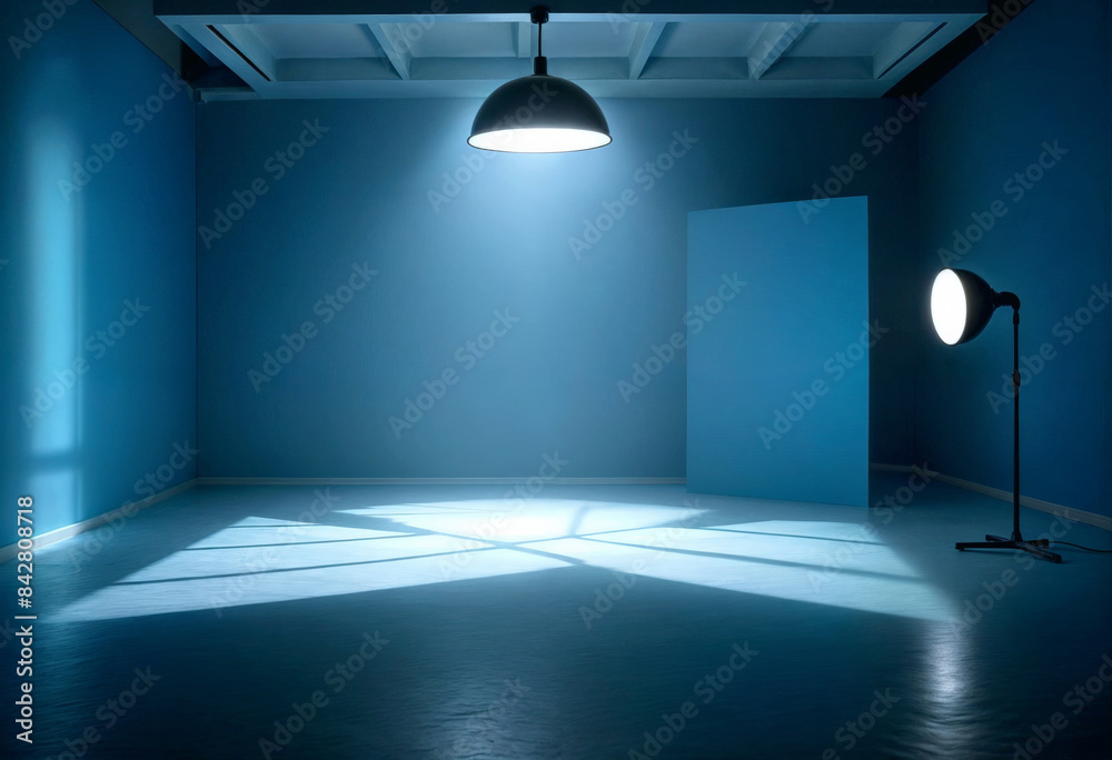 an empty photo studio with a blue wall, a light and a spotlight an empty photo studio with a blue wall, a light and a spotlight