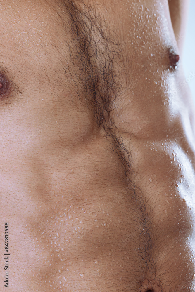 Fototapeta premium Man, chest and wet in studio for cosmetics, moisture and cleaning or sweat on backdrop. Male person, body care and water drops for wellness treatment or dermatology, grooming and hydration beauty
