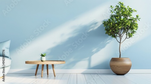 Round coffee table near light blue sofa and wooden pot with tree against blue wall with copy space