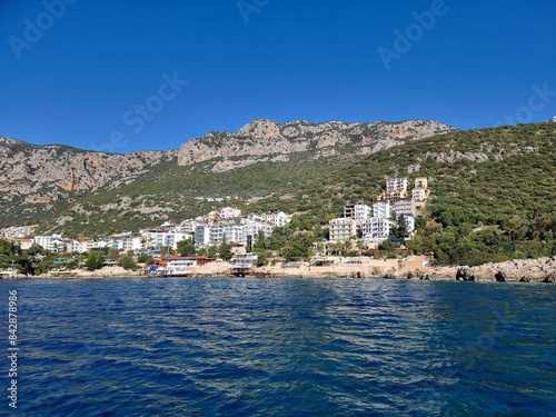Kash, Turkiye, view from the ship on the mediterranean sea to the city with white houses and green mountains around it