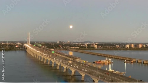 Full Moonrise time lapse over a long bridge with heavy traffic