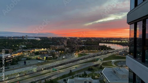 Bird view of a city and highway traffic in sunset and orange sky timelapse