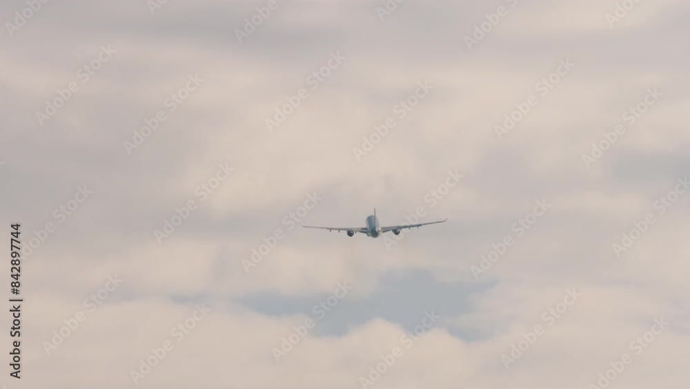 Jet airliner with unrecognizable livery rising in the sky, rear view, long shot. Airplane takeoff and climb. Departure flight