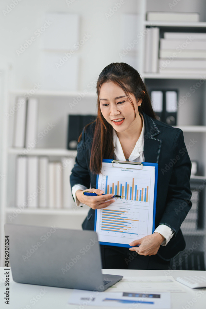 Businesswoman in a business suit is presenting a report on a laptop Businesswoman in a business suit is presenting a report on a laptop