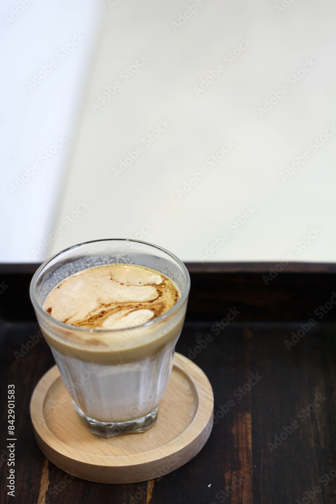 DIRTY coffee in clear glass on wooden table DIRTY coffee in clear glass on wooden table