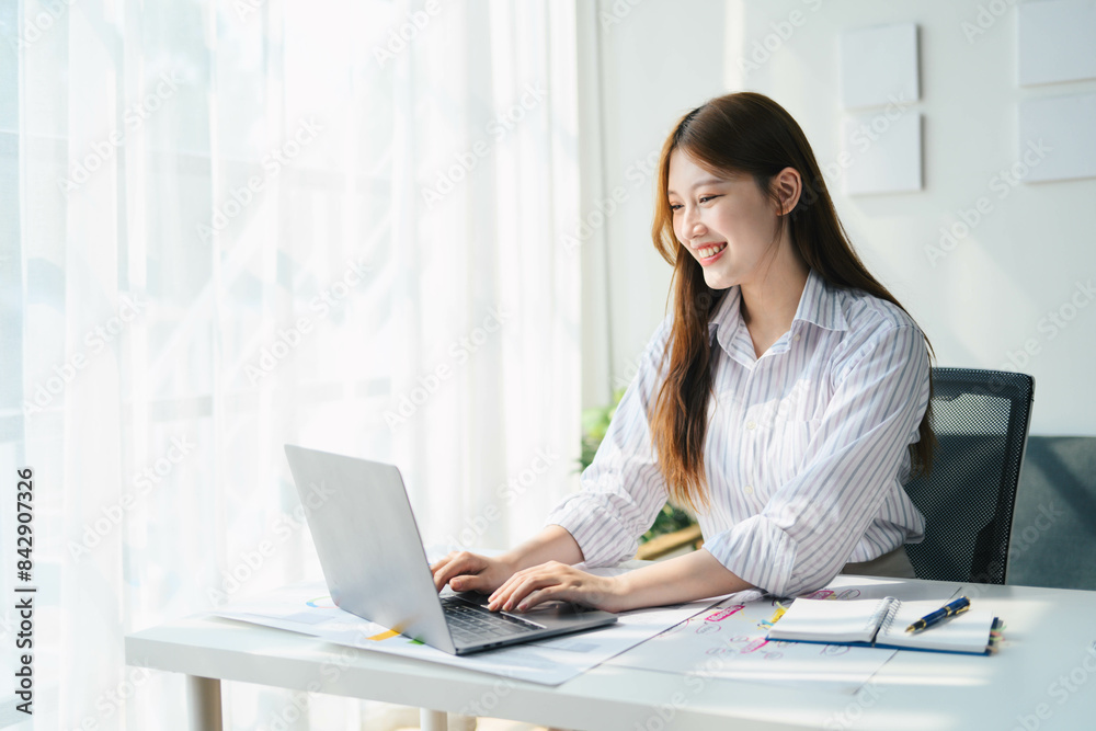 Student woman is sitting at a desk with a laptop and a notebook Student woman is sitting at a desk with a laptop and a notebook