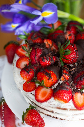 Birthday cake with strawberry jam and fresh berries coved with chocolate