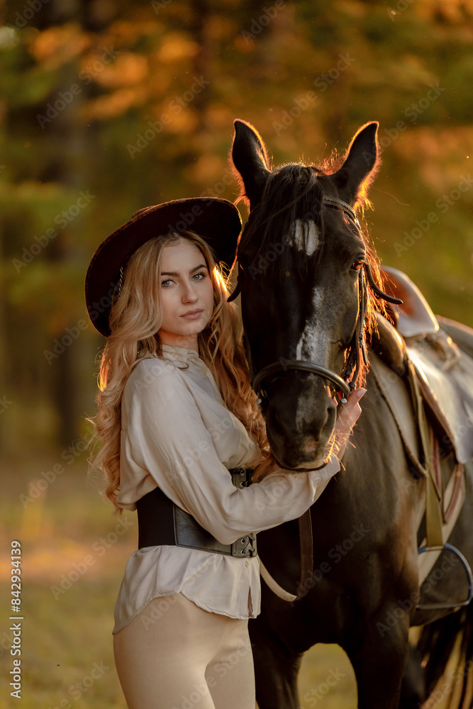 Obraz premium A young beautiful woman walks with her horse in the forest in early autumn. Walking with a horse in the forest.