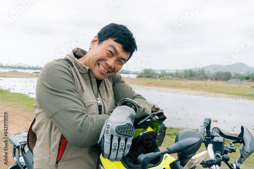 Portrait of a motorcyclist during moto trip outdoor near the lake, Korean Asian nationality photo