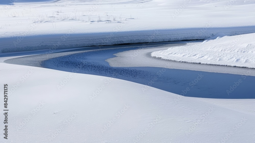 A the stark white landscape a patch of dark blue signifies the presence of a thaw pond providing a vital water source for wildlife in the frozen wilderness. A the stark white landscape a patch of dark blue signifies the presence of a thaw pond providing a vital water source for wildlife in the frozen wilderness.