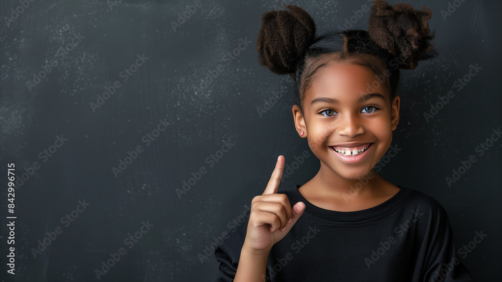 Girl Smiling and Pointing in Front of Blackboard