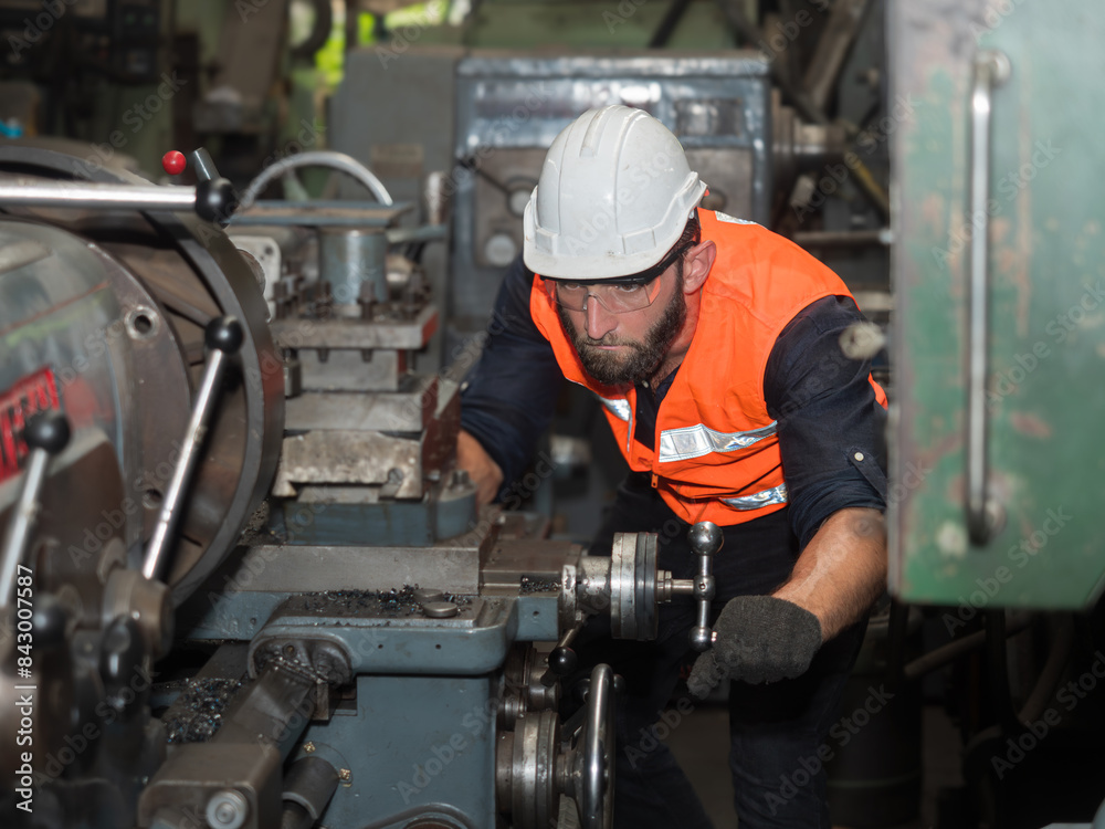 Confident factory workers are customizing machines in preparation for the production of industrial parts. Confident factory workers are customizing machines in preparation for the production of industrial parts.