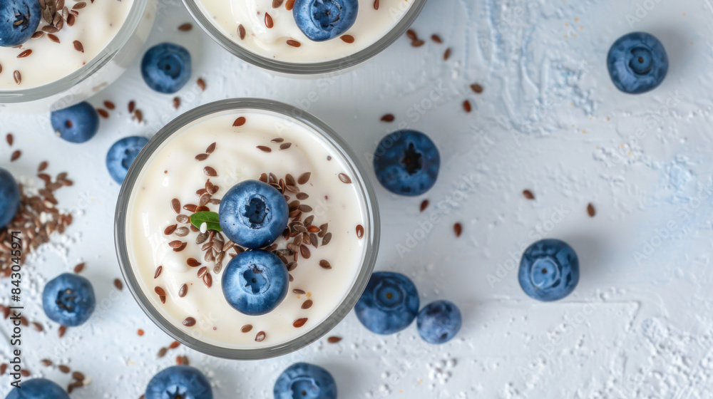 Yogurt parfait with flax seeds and blueberries, shot from above on a light background.