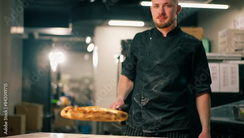 close up in a professional kitchen in a pizzeria pizza with bacon is prepared from the oven