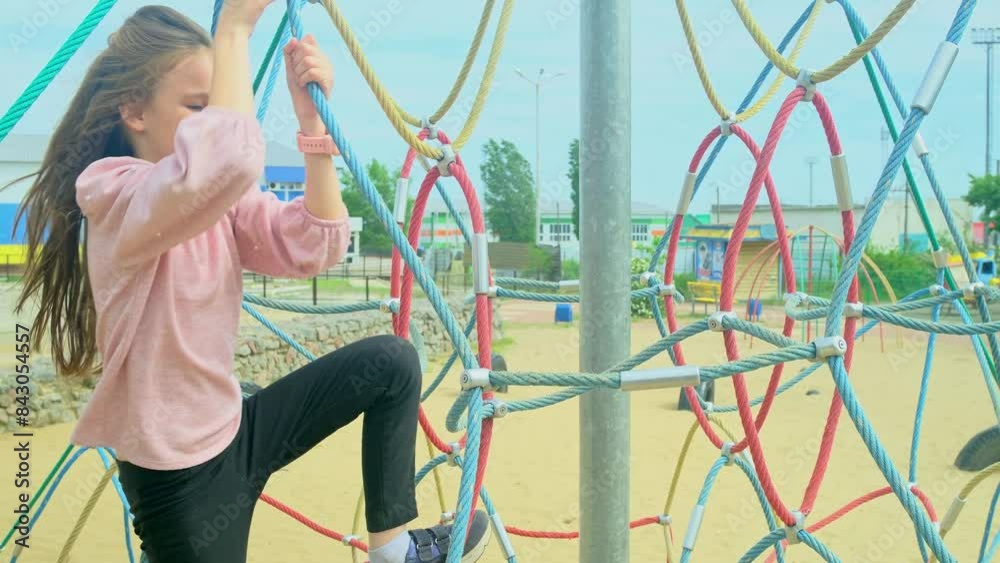 Happy little girl climbing on outdoor playground
