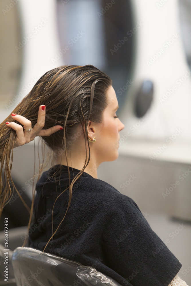 Fototapeta premium Hairdresser Combing Wet Hair of Female Client