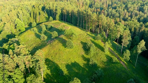 Scenic aerial view of Stirniai mound surrounded with green trees, located in Neris Regional Park near Vilnius, on sunny summer day. Landmarks and destination scenics of Lithuania. photo