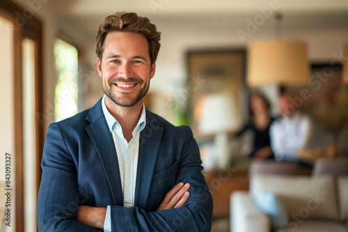 The real estate agent's confident demeanor is highlighted in a closeup portrait, set against the backdrop of a blurred house interior where potential buyers are seen in the distanc photo