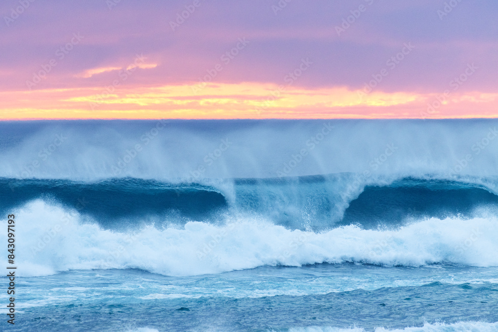 Ocean waves creashing and seaspray at pink and orange sunset Ocean waves creashing and seaspray at pink and orange sunset