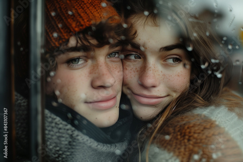 Young Couple Smiling Through Window on Snowy Day