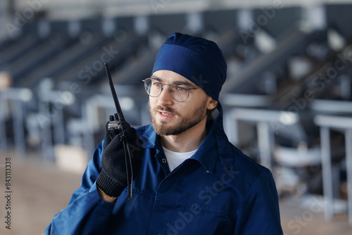 Industry worker uses walkie talkie for communication in industrial production photo