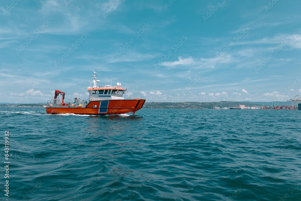 Coast guard or rescue boat in the bay of Koper, Slovenia. Typical rescue boat with orange hull and white superstructure. Boat patrilling around the port of Koper Coast guard or rescue boat in the bay of Koper, Slovenia. Typical rescue boat with orange hull and white superstructure. Boat patrilling around the port of Koper