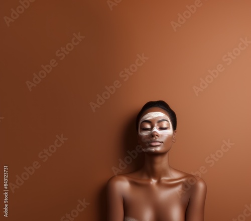 Beautiful young African black woman with facial mask on her face on a background with Copy Space. Young African American Woman with clay mask on her face. Beautiful African female with Facial Mask. 
