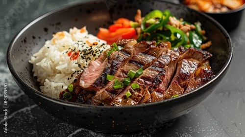 Grilled steak filet accompanied by a chicken rice bowl