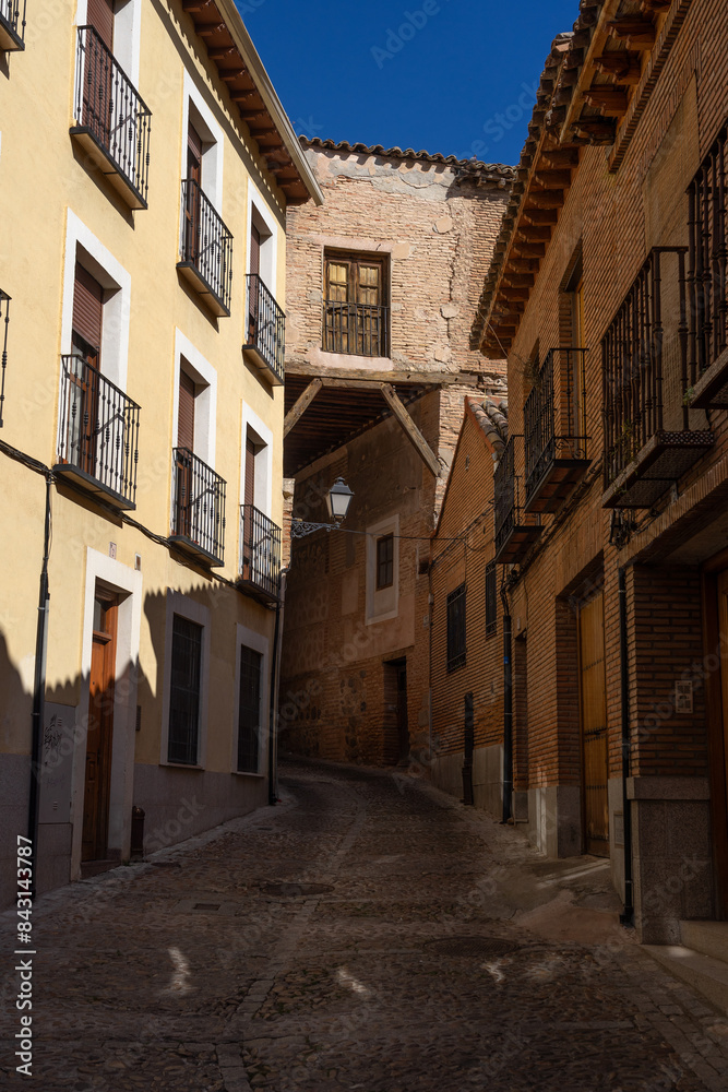 Fototapeta premium Doncellas street in the UNESCO World Heritage site of the city of Toledo since Valley lookout in a sunny day. Castilla la Mancha, Spain.