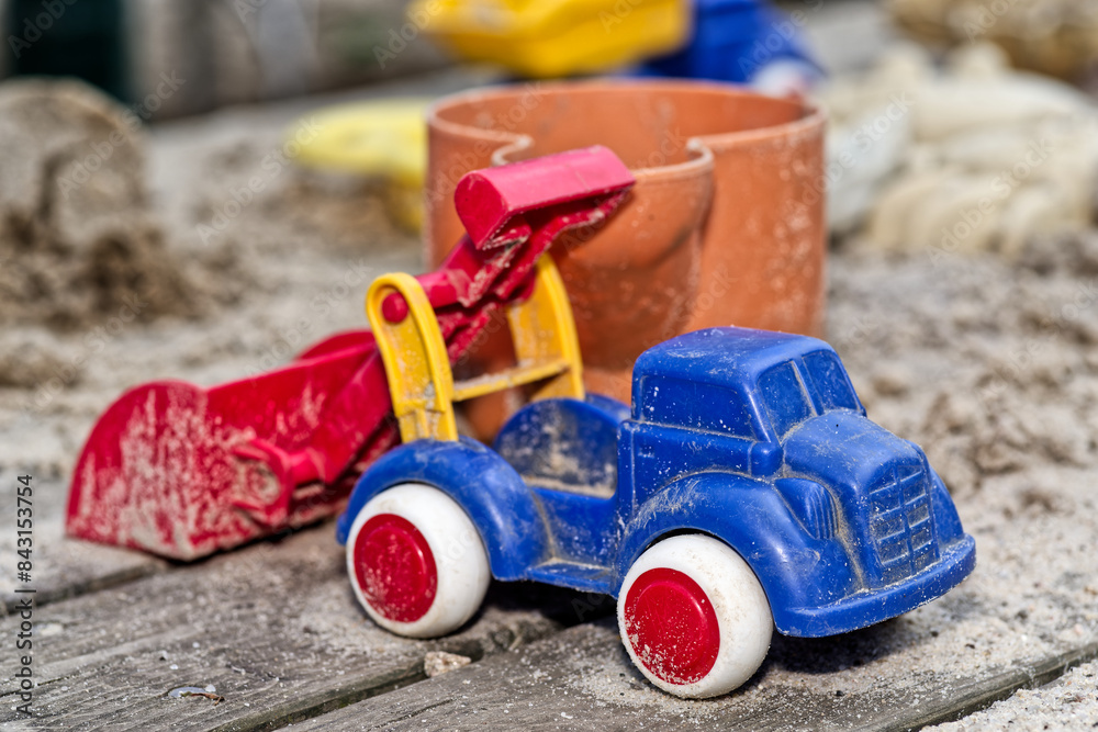 Childrens toy car in the sand in close-up view Childrens toy car in the sand in close-up view
