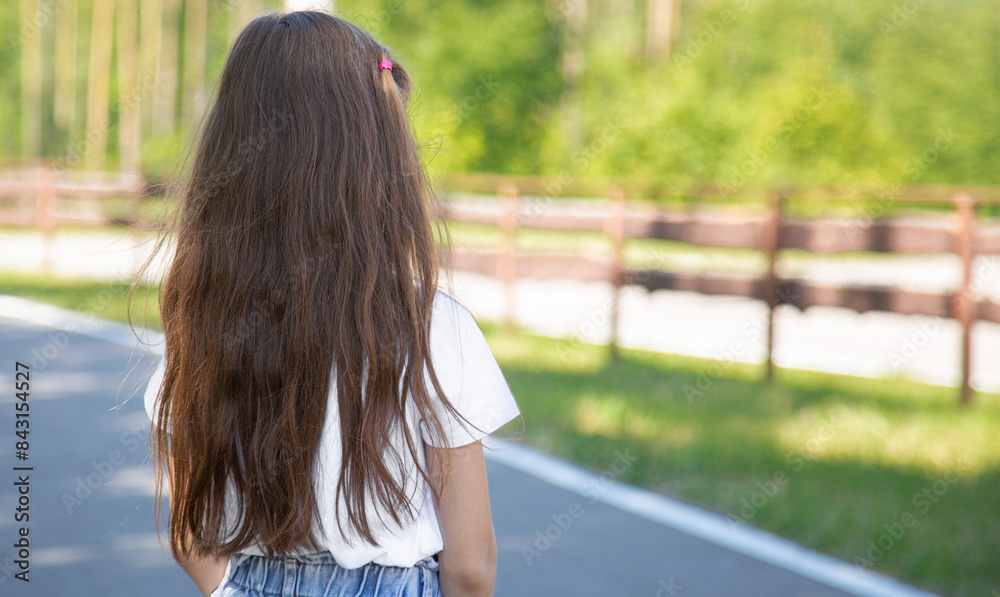 Positive pretty little girl going road on park in the white t-shirt and jeans shorts sunny weather warm season. Positive pretty little girl going road on park in the white t-shirt and jeans shorts sunny weather warm season.