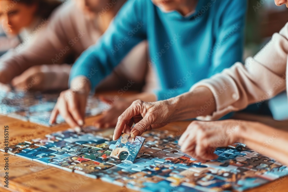 Family working together on a large jigsaw puzzle. Close-up indoor photography. Teamwork and intergenerational bonding concept. Family working together on a large jigsaw puzzle. Close-up indoor photography. Teamwork and intergenerational bonding concept.