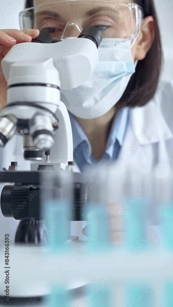 Female scientist using microscope in laboratory Female scientist using microscope in laboratory