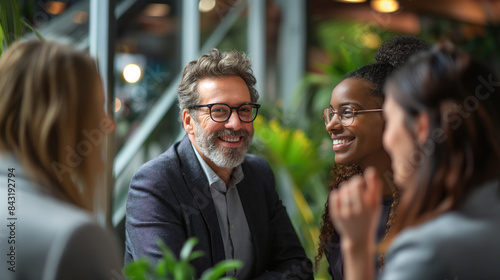 A diverse group of office professionals talking in green area of the office