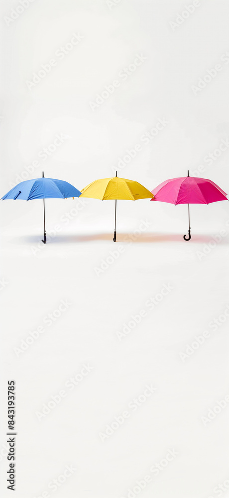 three colorful umbrellas stretched out against a white background, showcasing their vibrant colors and design.