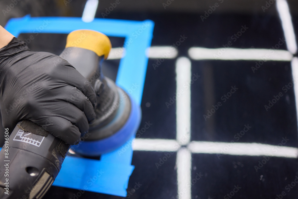 Fototapeta premium Person using machine to polish cars automotive exterior