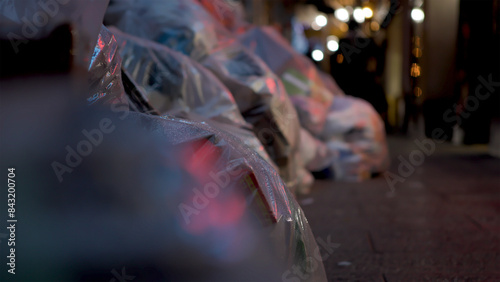 Bags of trash on city streets after rain at night