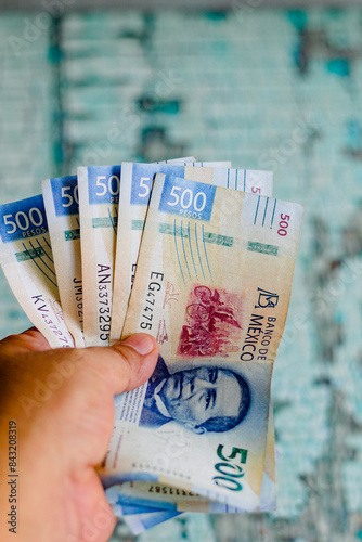 Two thousand five hundred Mexican pesos on a wooden table, banknotes