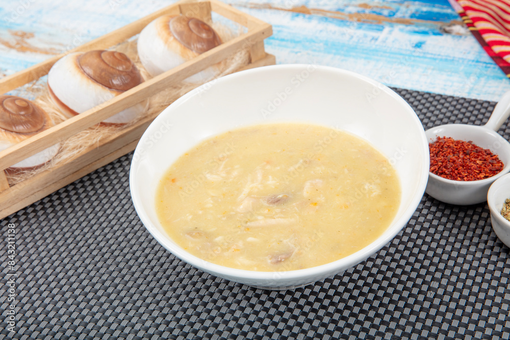 Fish soup in a bowl. Fish soup with cream, sauces, lemon, herbs and croutons on wooden background. Fish soup in a bowl. Fish soup with cream, sauces, lemon, herbs and croutons on wooden background.