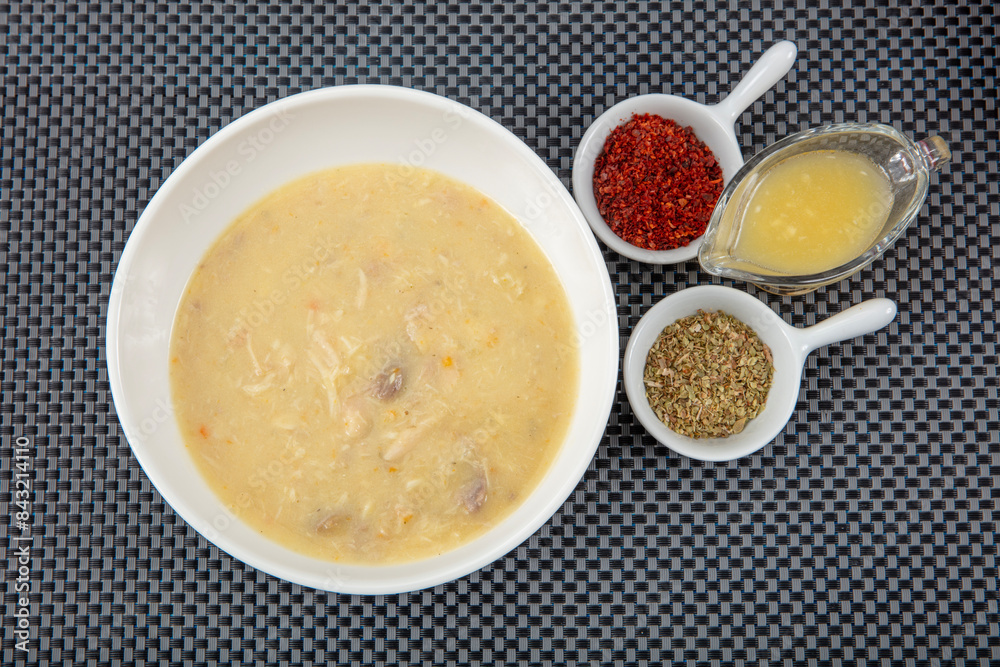 Fish soup in a bowl. Fish soup with cream, sauces, lemon, herbs and croutons on wooden background. Fish soup in a bowl. Fish soup with cream, sauces, lemon, herbs and croutons on wooden background.