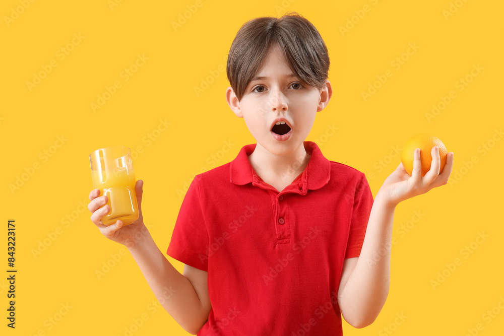 Shocked little boy with orange and glass of juice on color background Shocked little boy with orange and glass of juice on color background