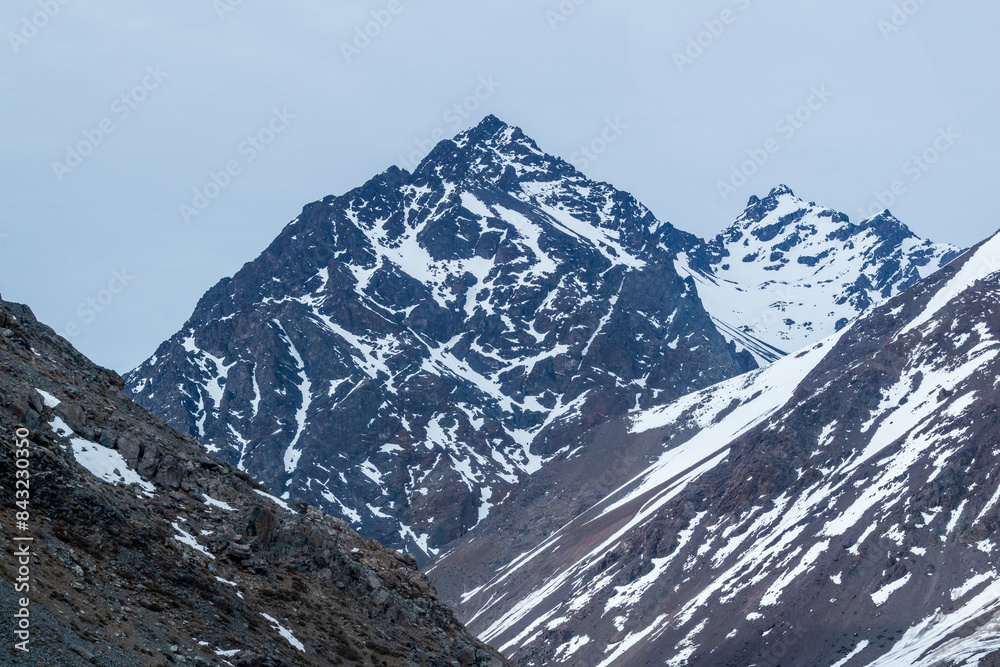 A freezing day high in the Andes Mountains in Chile, with mountains covered in snow.
