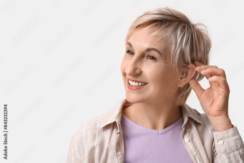 Mature woman with hearing aid on white background Mature woman with hearing aid on white background