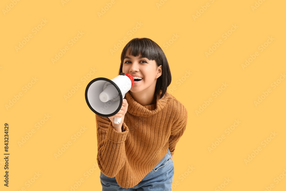Young woman with megaphone on yellow background Young woman with megaphone on yellow background