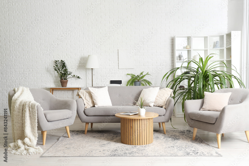 Fototapeta premium Interior of living room with sofa, armchairs and houseplants