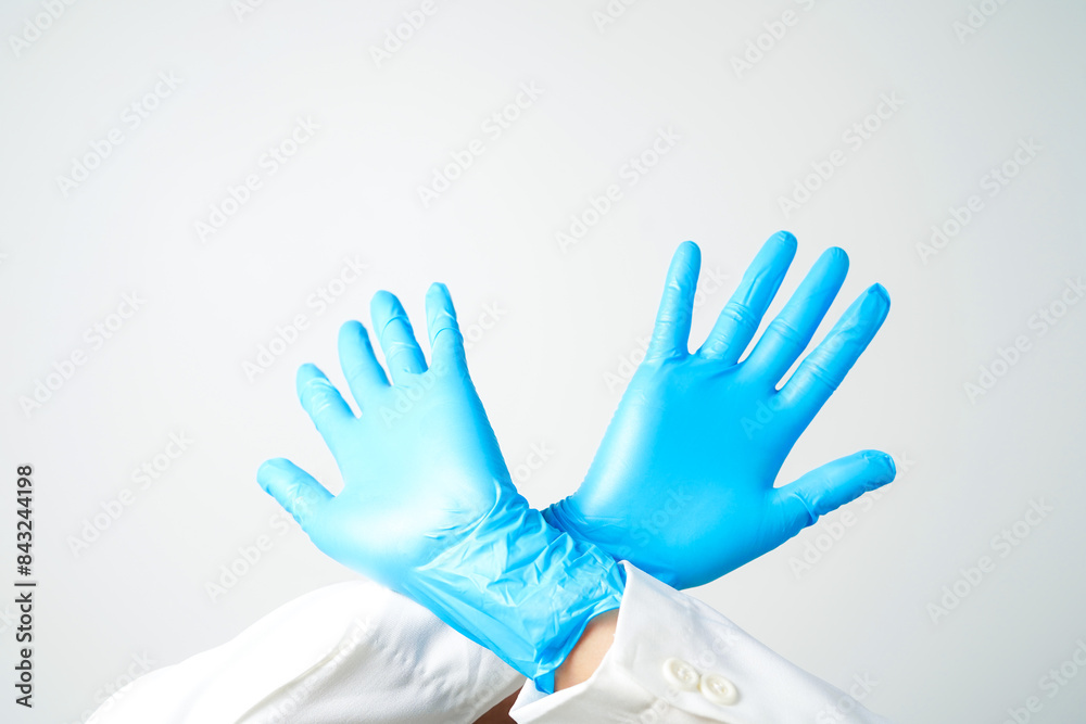 Obraz premium Stop gesture, arms crossed in blue gloves, sign protest, rejection, on white background
