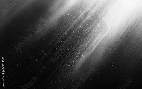 Grainy abstract black and white image capturing ethereal light rays and particles  creating a dreamy and mysterious atmosphere.