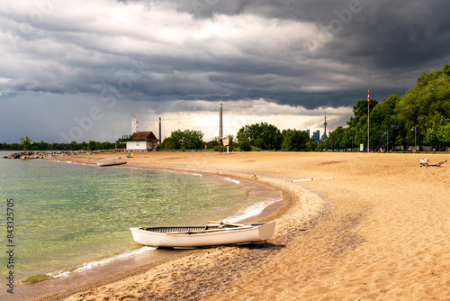 Photography beach with white wooden rowboat pulled up at water's edge and dramatic cloud fil