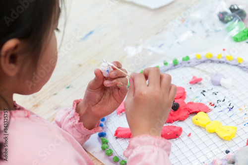 絵画教室で粘土を使った工作に励む小学生の子ども