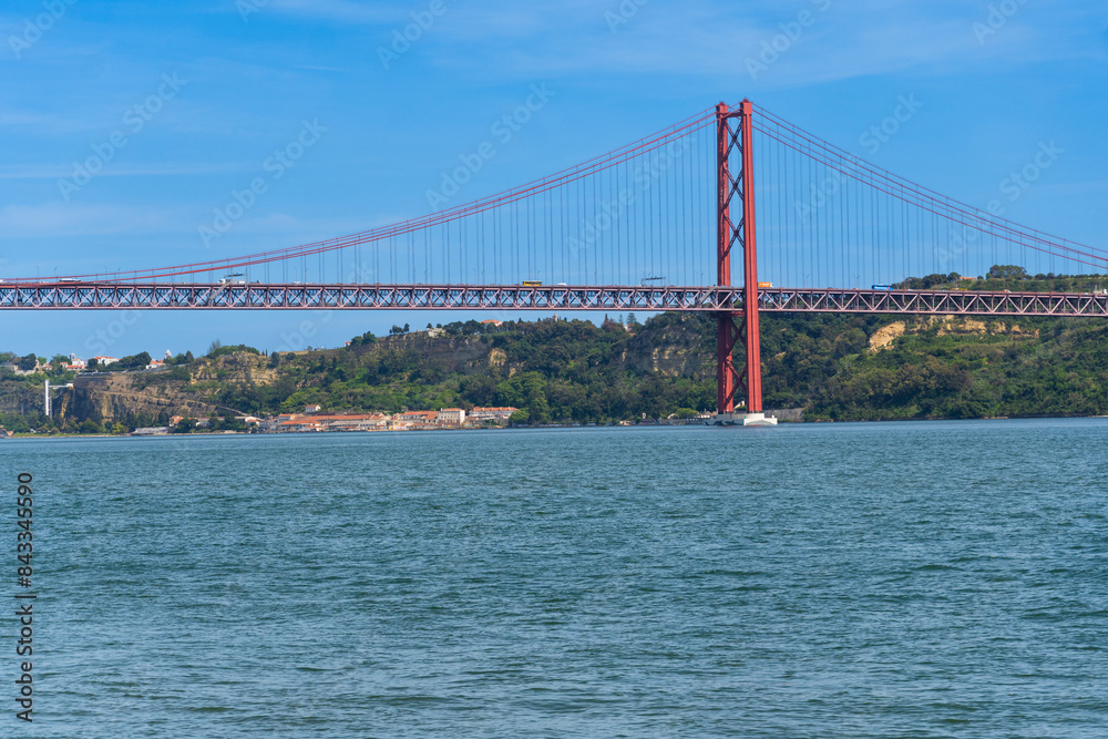 Fototapeta premium The 25th April Bridge, Ponte 25 de Abril in Portuguese, the longest suspension bridge in Europe. Connecting the city of Lisbon, capital of Portugal, to the municipality of Almada over the Tagus River.